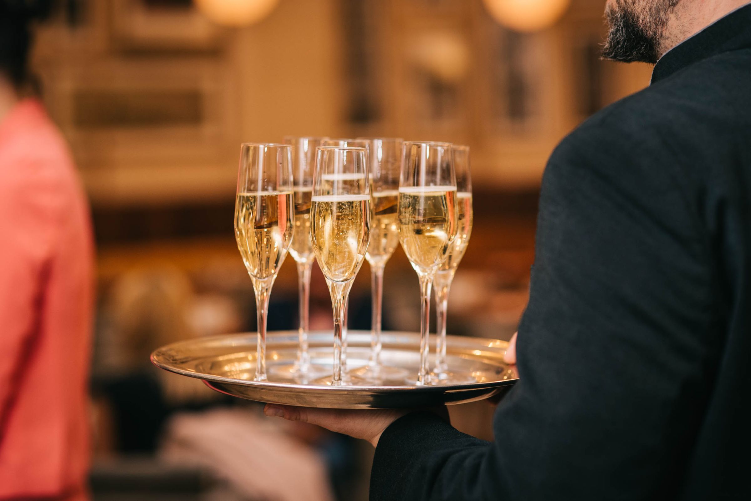 An event server carrying a tray of champagne
