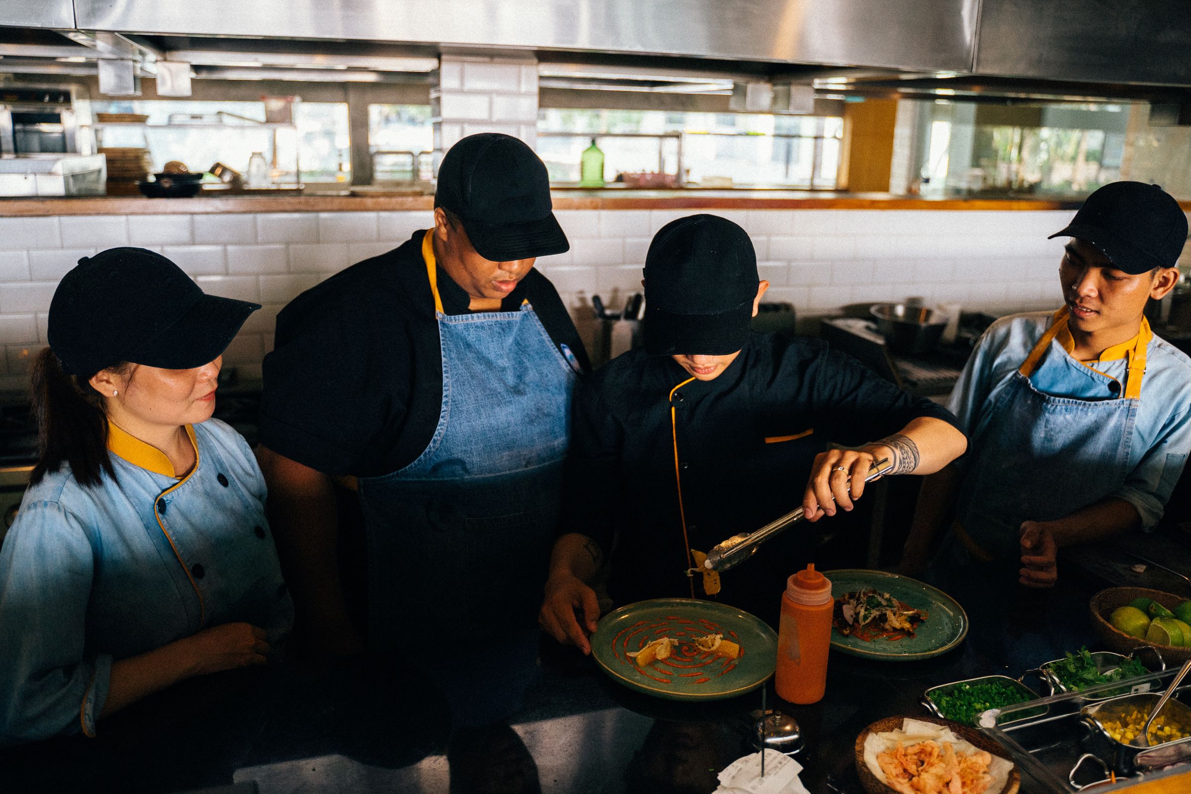 A kitchen team reviewing dishes together during service